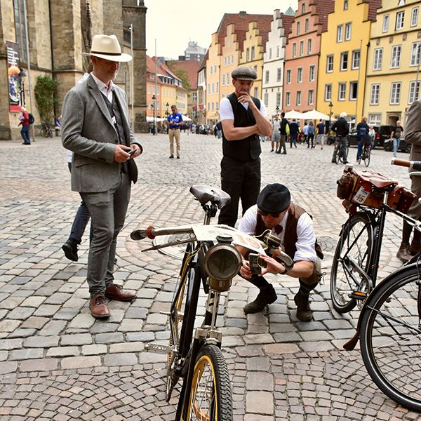 Männer mit Fahrrädern auf Kirchplatz - Tweet Run 2021