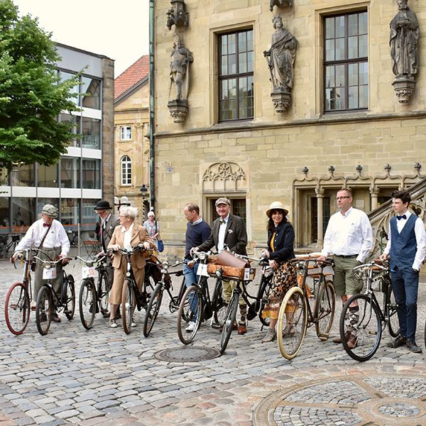 Menschengruppe mit Fahrrädern vor Kirchgebäude - Tweet Run 2021