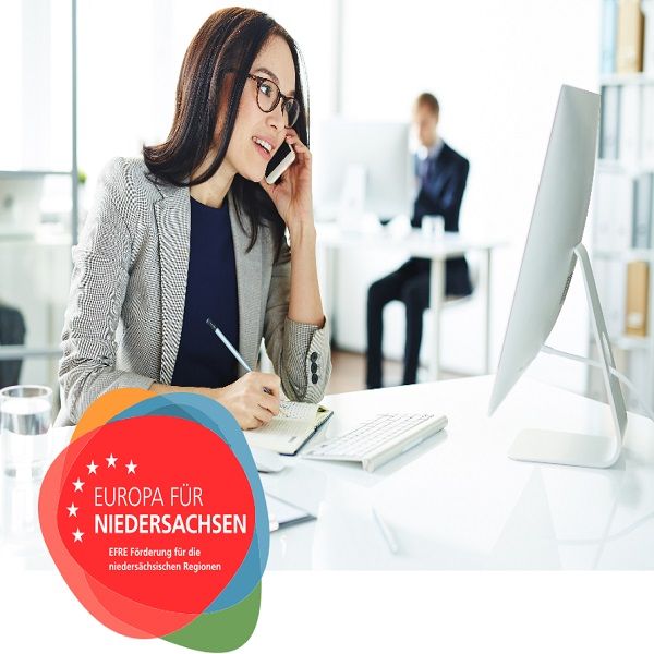 Business Frau telefoniert und macht sich Notizen während Sie vor einem Computer sitzt - Europa für Niedersachen